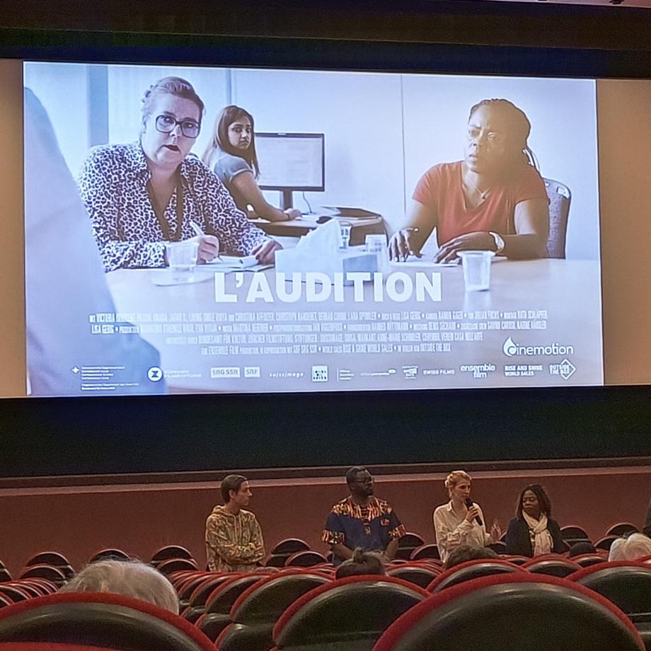 sinema salonunda film sonrası soru cevap bölümünde çekilmiş bir fotoğraf. Ekranda filmin afişi var.