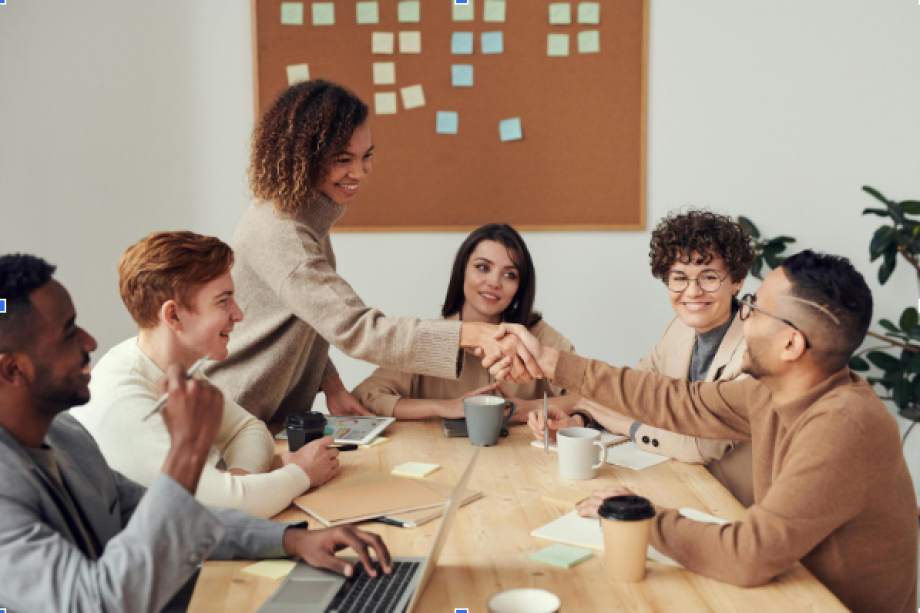 Bir masanın etrafında bir grup insan sohbet ediyor. 