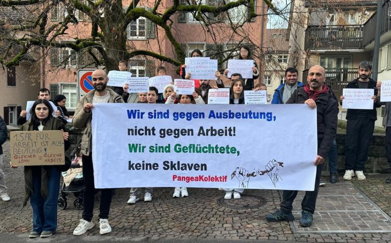 basın açıklamasında ellerinde dövizleri ve pankartla duran kitle fotoğrafı