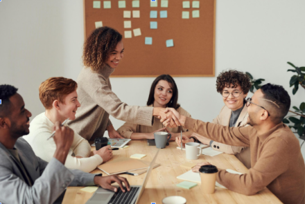 Bir masanın etrafında bir grup insan sohbet ediyor. 